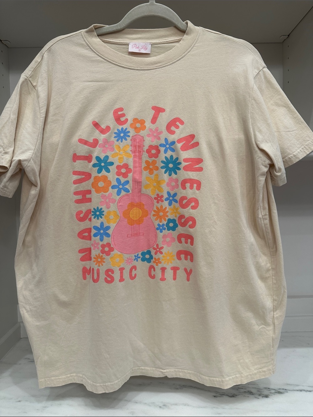 Pink Lily  small cream tee shirt.  Nashville Tenn Music City logo. Like new